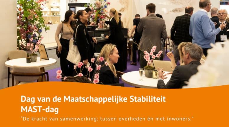 Sprekende vrouw met toekijkende mensen op de MAST-dag